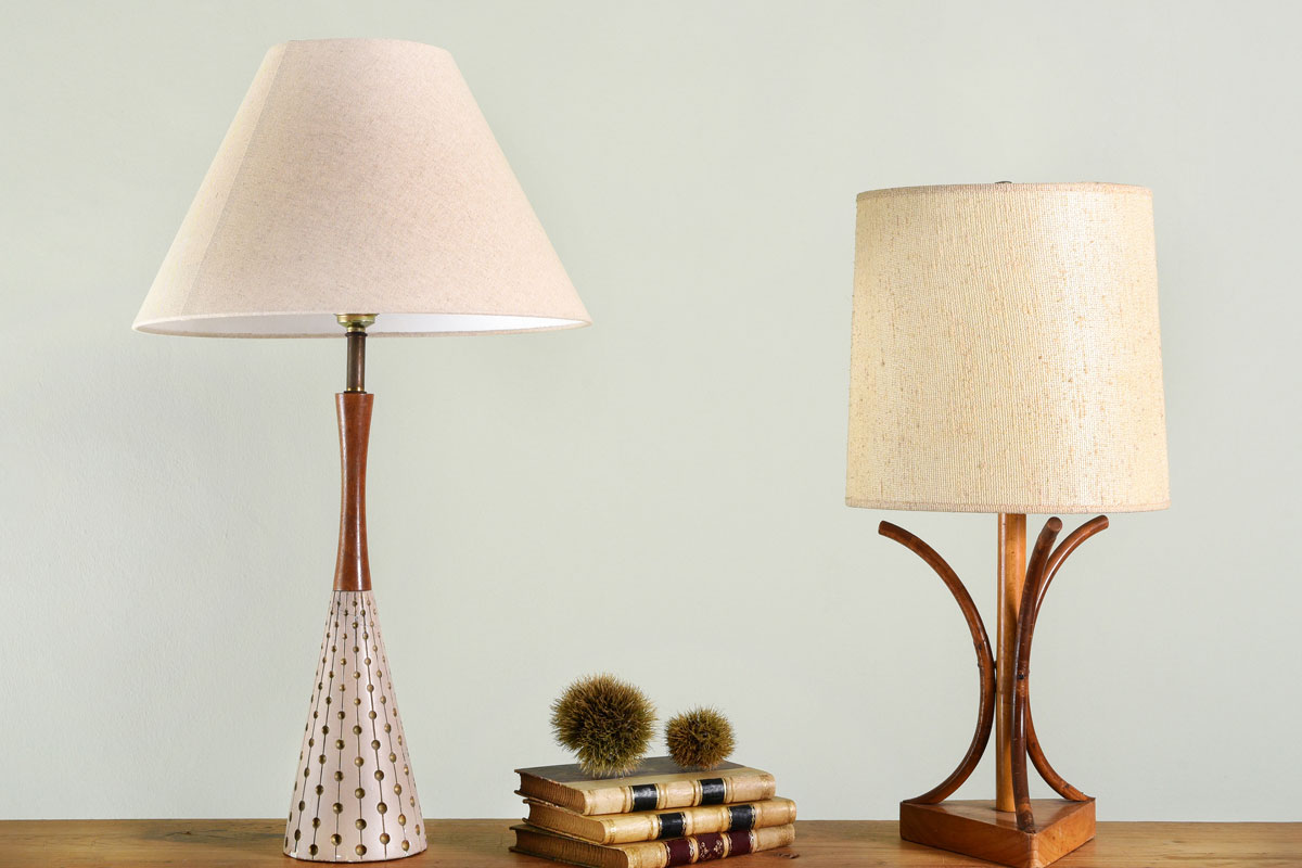 Books on wooden shelf between two vintage house lights with classic style lamp shades