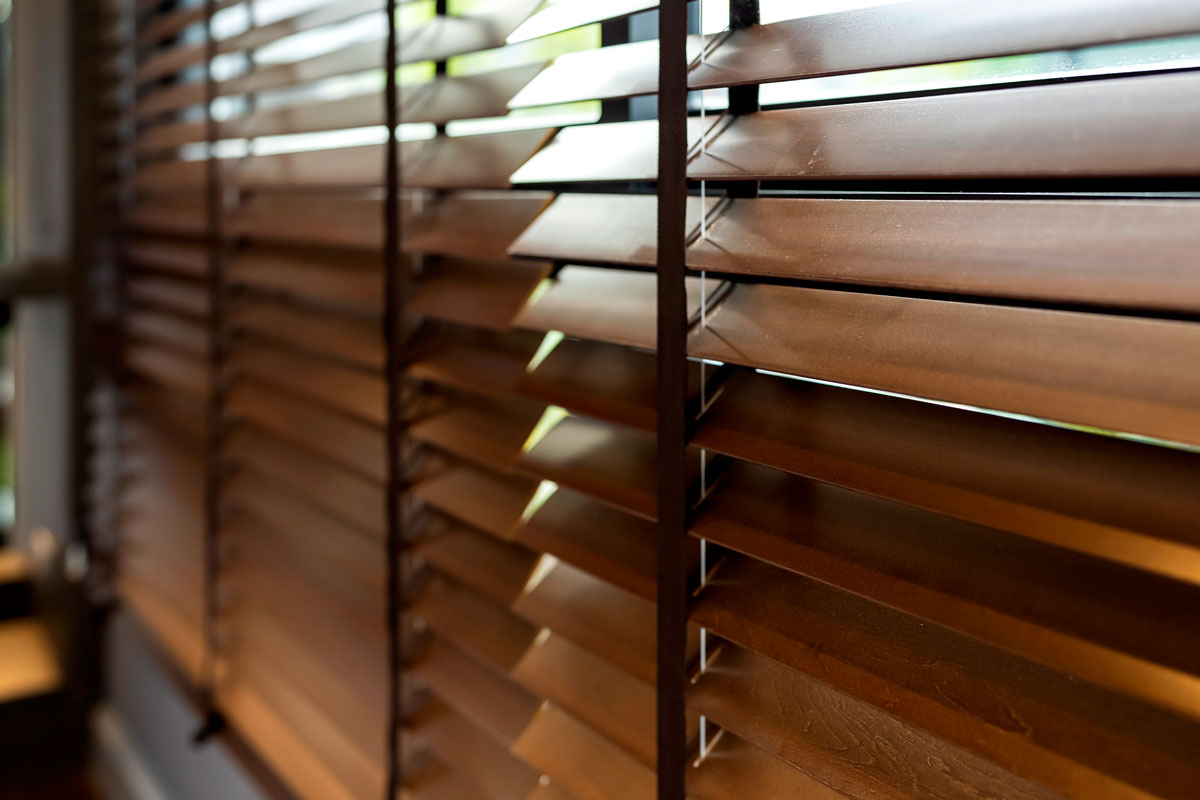 Brown Venetian blinds inside an office room of a smalla house