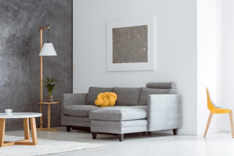 Canary yellow color accent in simple open living room interior with gray couch, What's The Best Paint Finish For An Accent Wall?