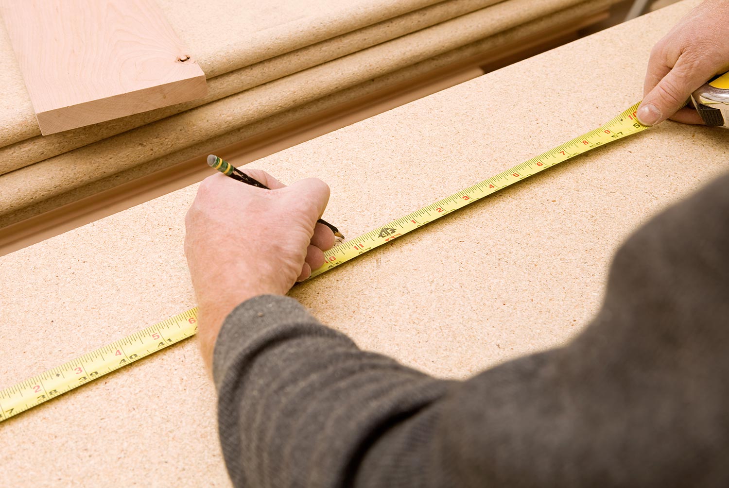 Carpenter measuring and marking stair tread for a cut