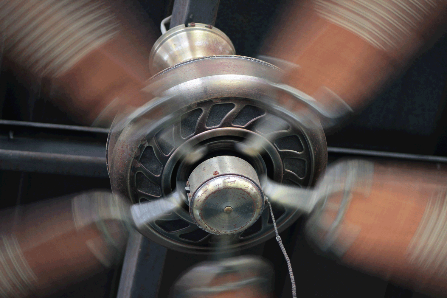 Ceiling fan blades are spinning and running.