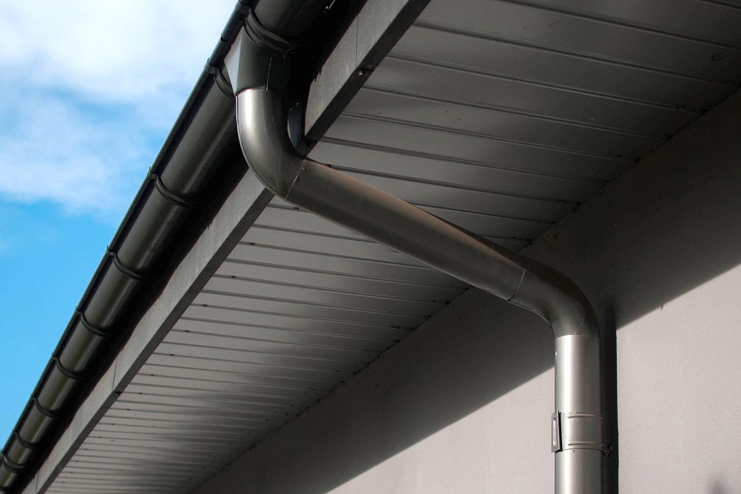 Coated rain gutter and rain water pipe at a roof