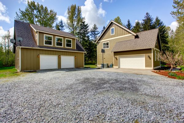 Countryside house exterior with garage view of entrance and gravel driveway, How Wide Should A Gravel Driveway Be?