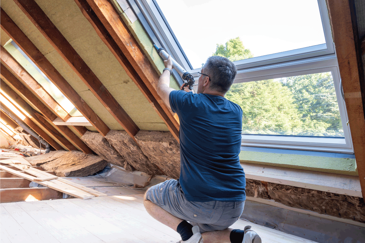 Craftsman caulking a new window in the attic. How To Clean Up After Caulking