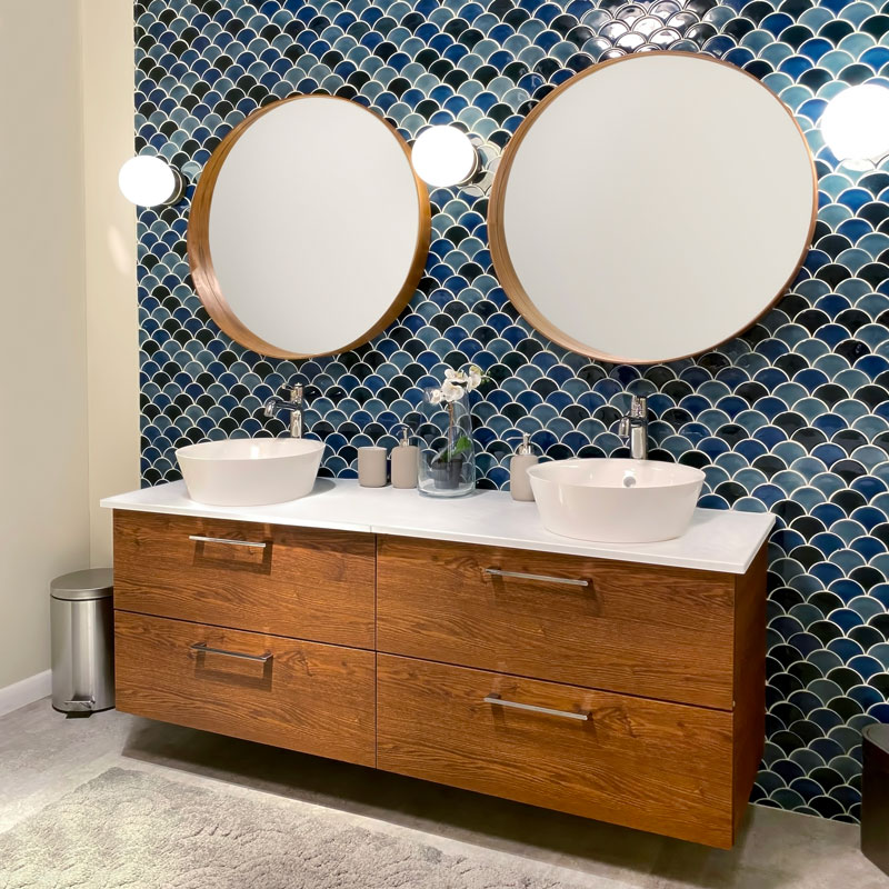 Double round mirror vanity with wooden cabinets and white countertop