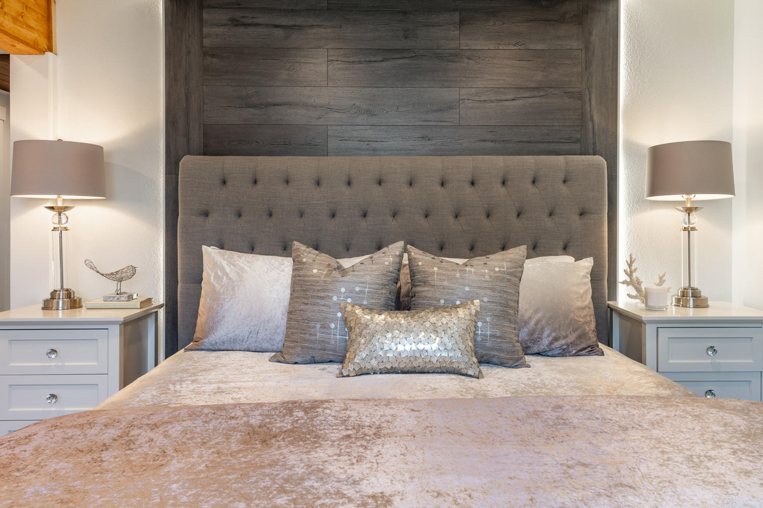 Elegant bedroom in greys soft pastels staged upholstered headboard soft pillows and wooden feature wall
