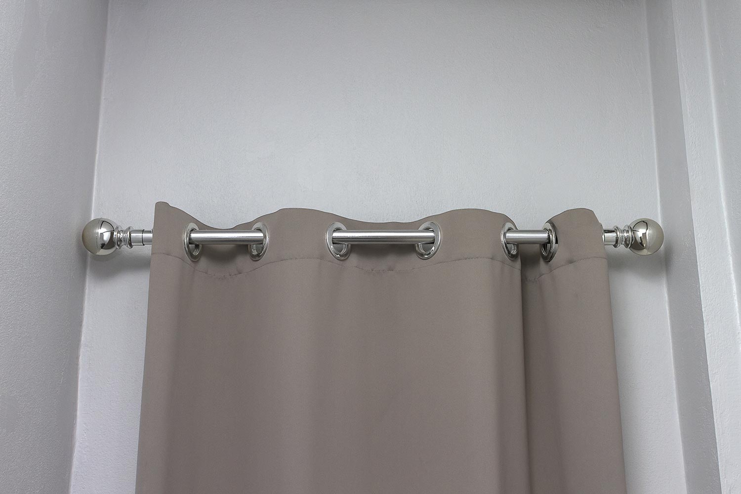 Gray curtain and stainless bar hanging on wall