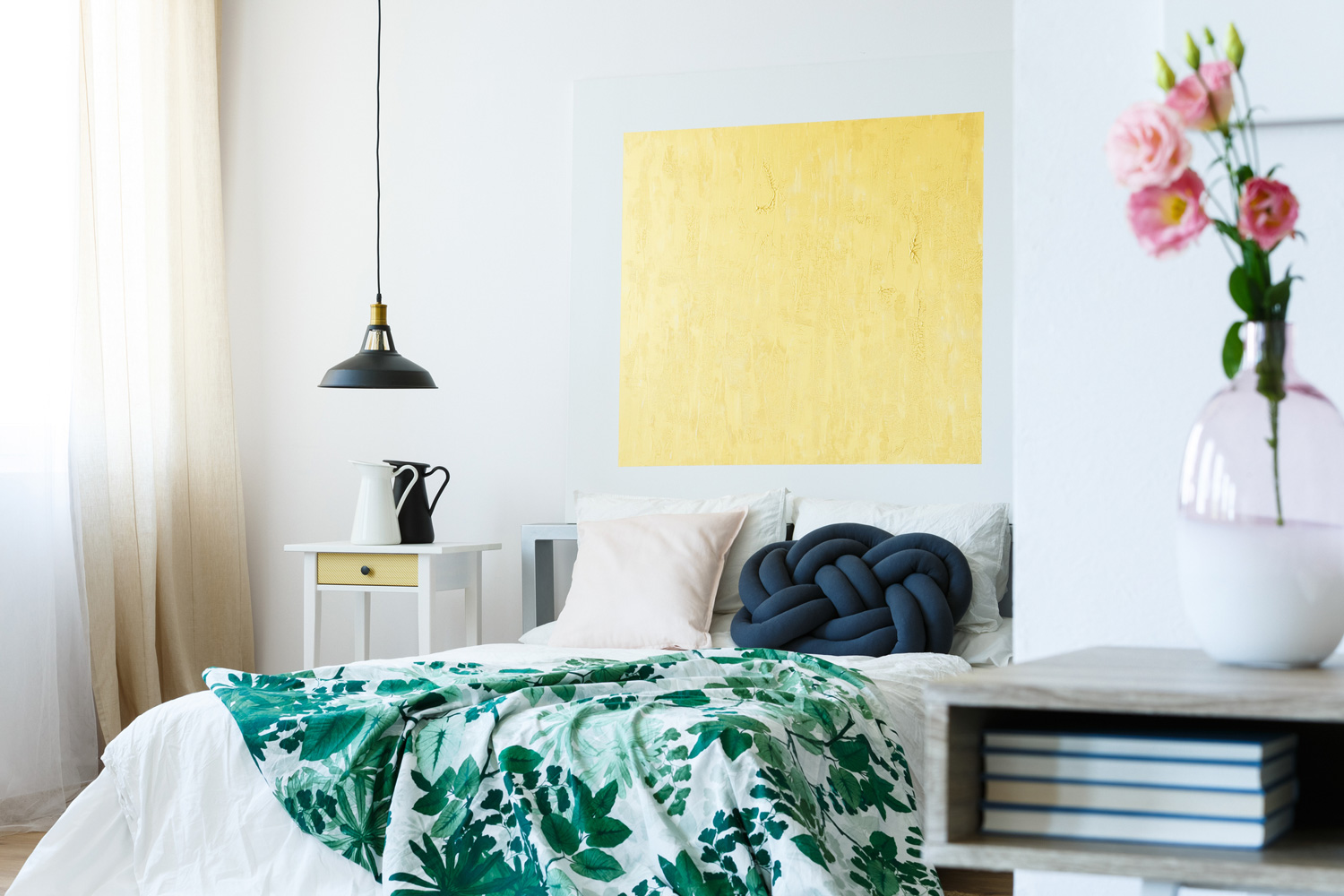 Guest bedroom with green tropical bedding and yellow artwork