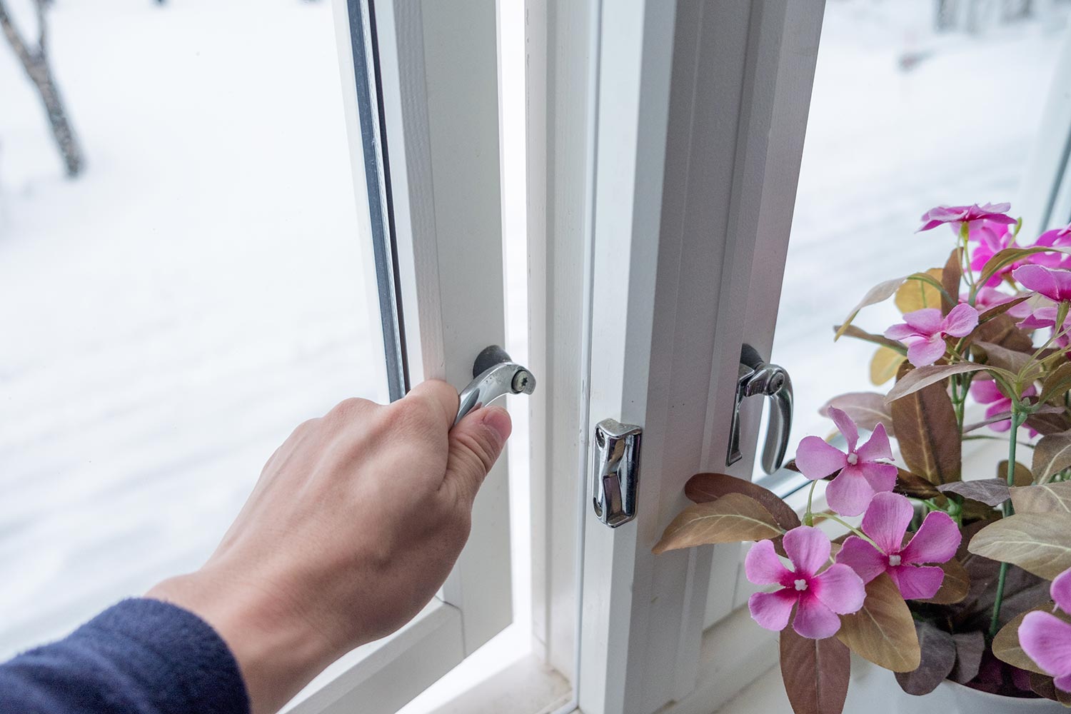 Hand opening window with flower decoration in winter