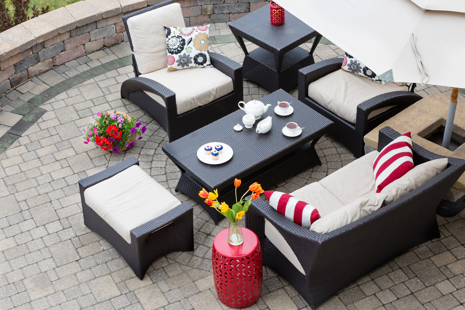 High Angle View of Upscale Patio Set, Dark Wicker Luxury Furniture with Comfortable Cushions on Outdoor Stone Patio of Affluent Home
