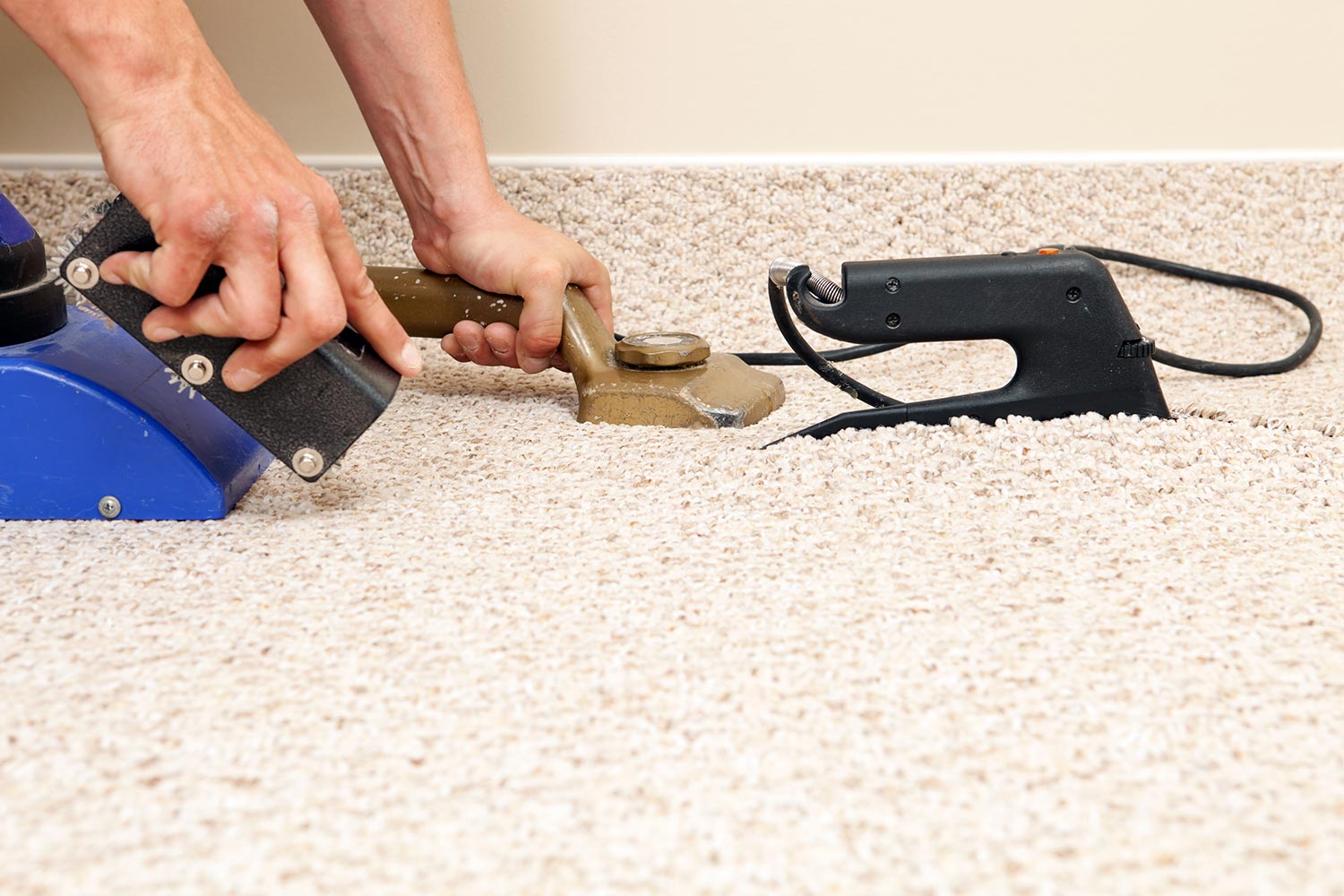 Installer joining two carpet pieces with iron
