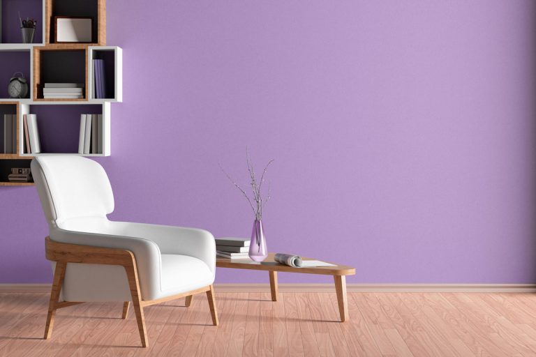 Interior of living room with white leather armchair, wooden triangular coffee table, What Color Goes With Mauve Walls?