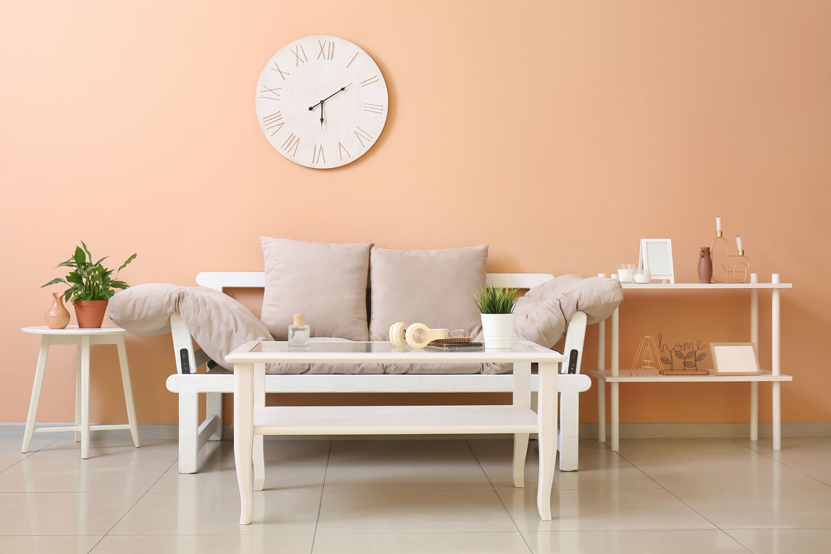 Interior of stylish living room with light pink wall with clock on a wall attached