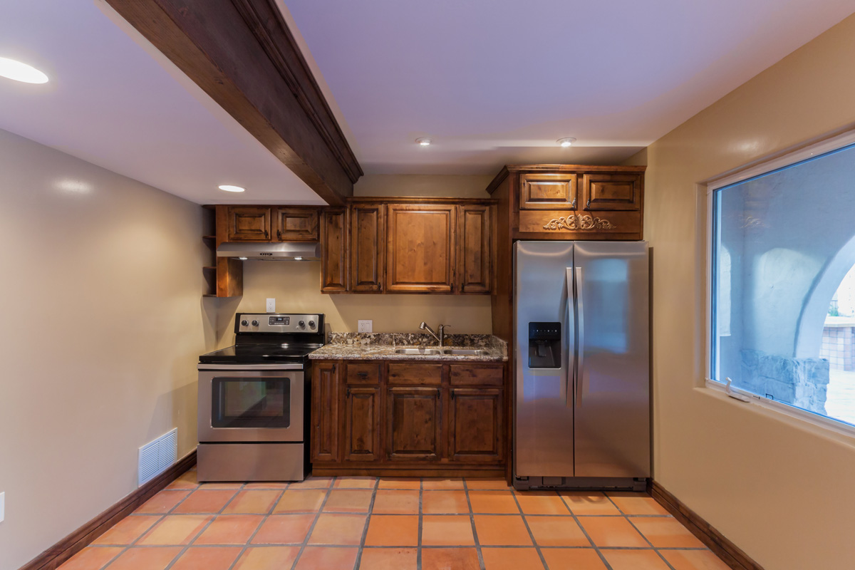 Kitchen with saltillo tile and beam ceiling