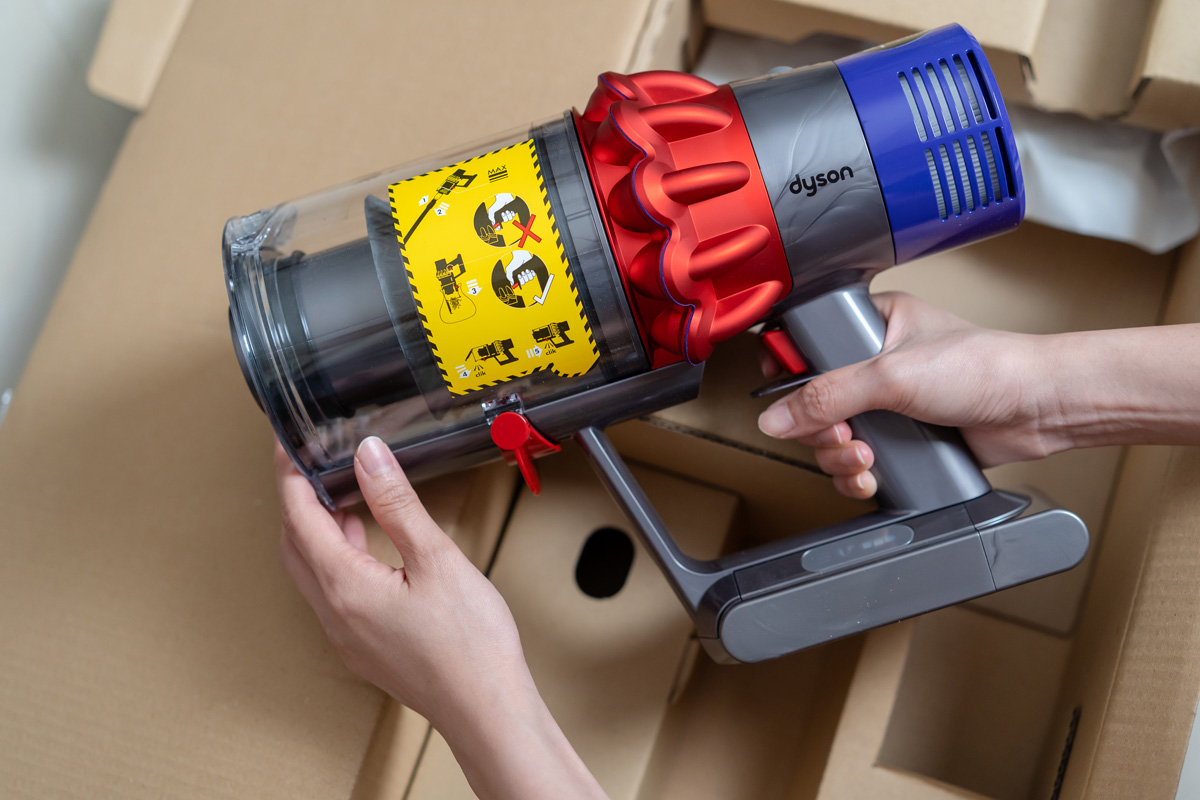 Lady’s hand touching the brand new Dyson Cyclone V10 Fluffy vacuum cleaner during open box