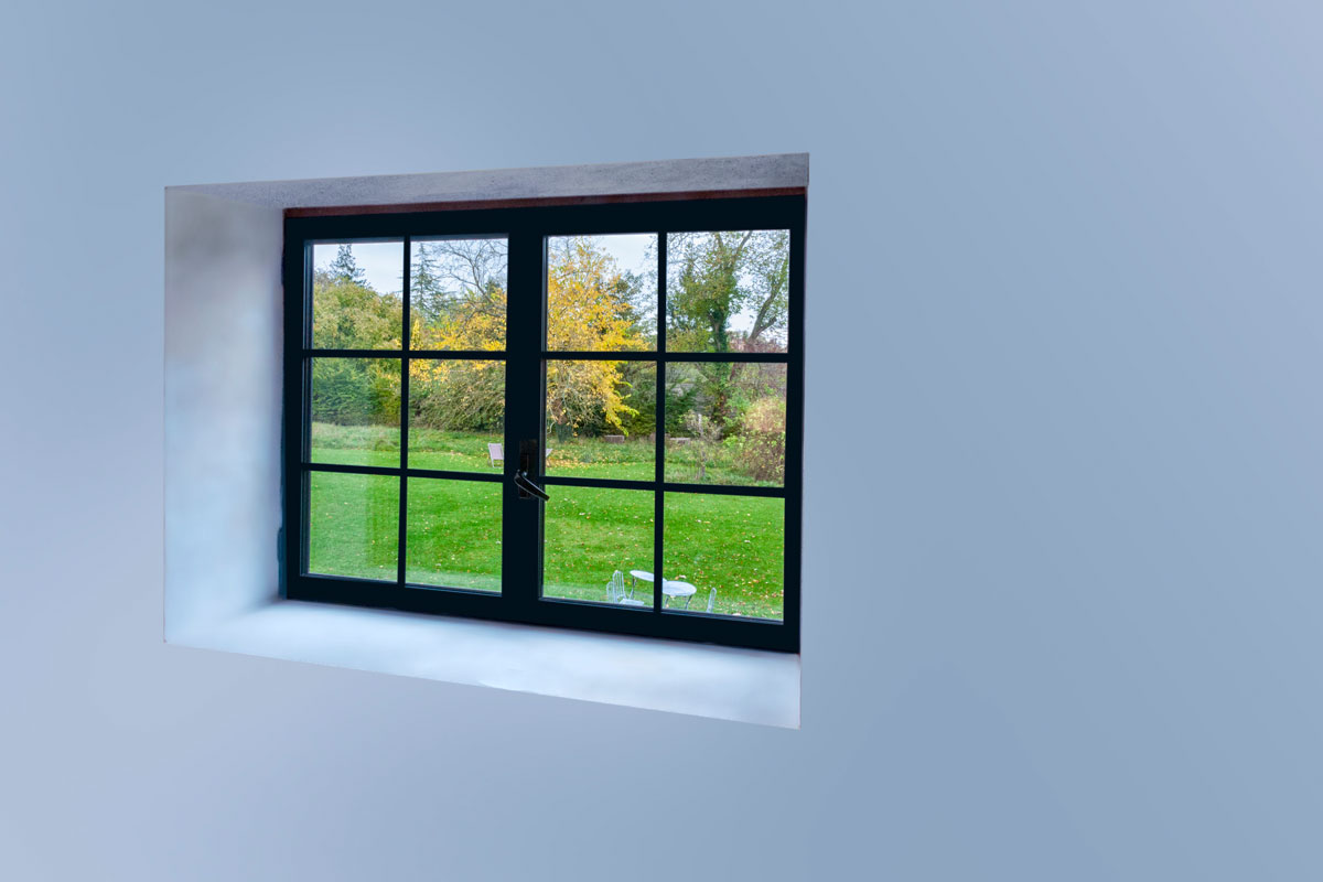 Large black aluminum open window with scenic nature view
