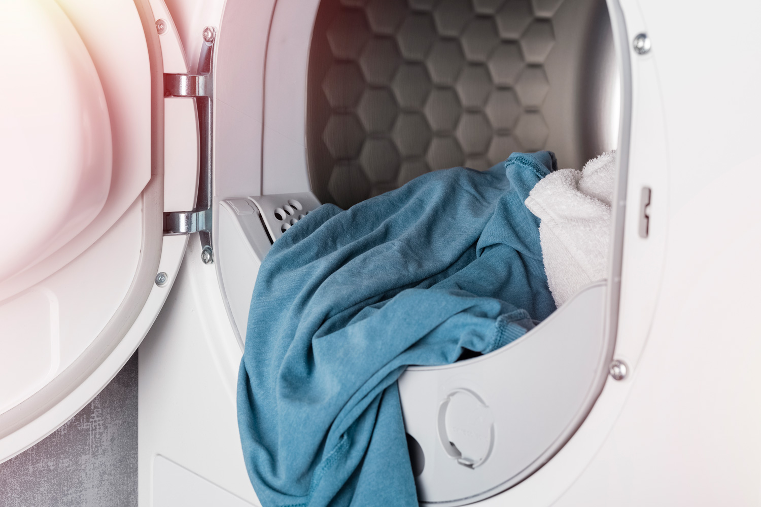Clean linen in the washing machine or dryer, close-up. Laundry concept
