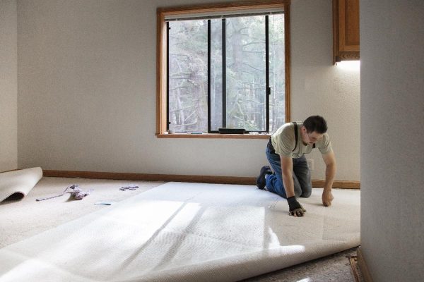 A man installing carpeting in home, How To Fit A Carpet Yourself?