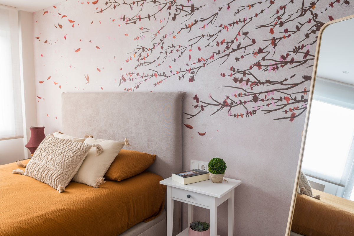 Modern Japanese inspired bedroom with a orange bedding bed with a wall painted with a cherry blossom tree