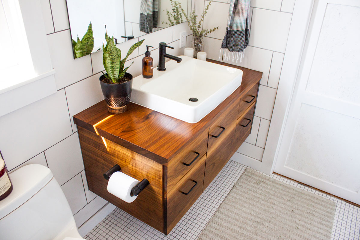 Modern decorated bathroom vanity in a modern white bathroom with natural light and plants