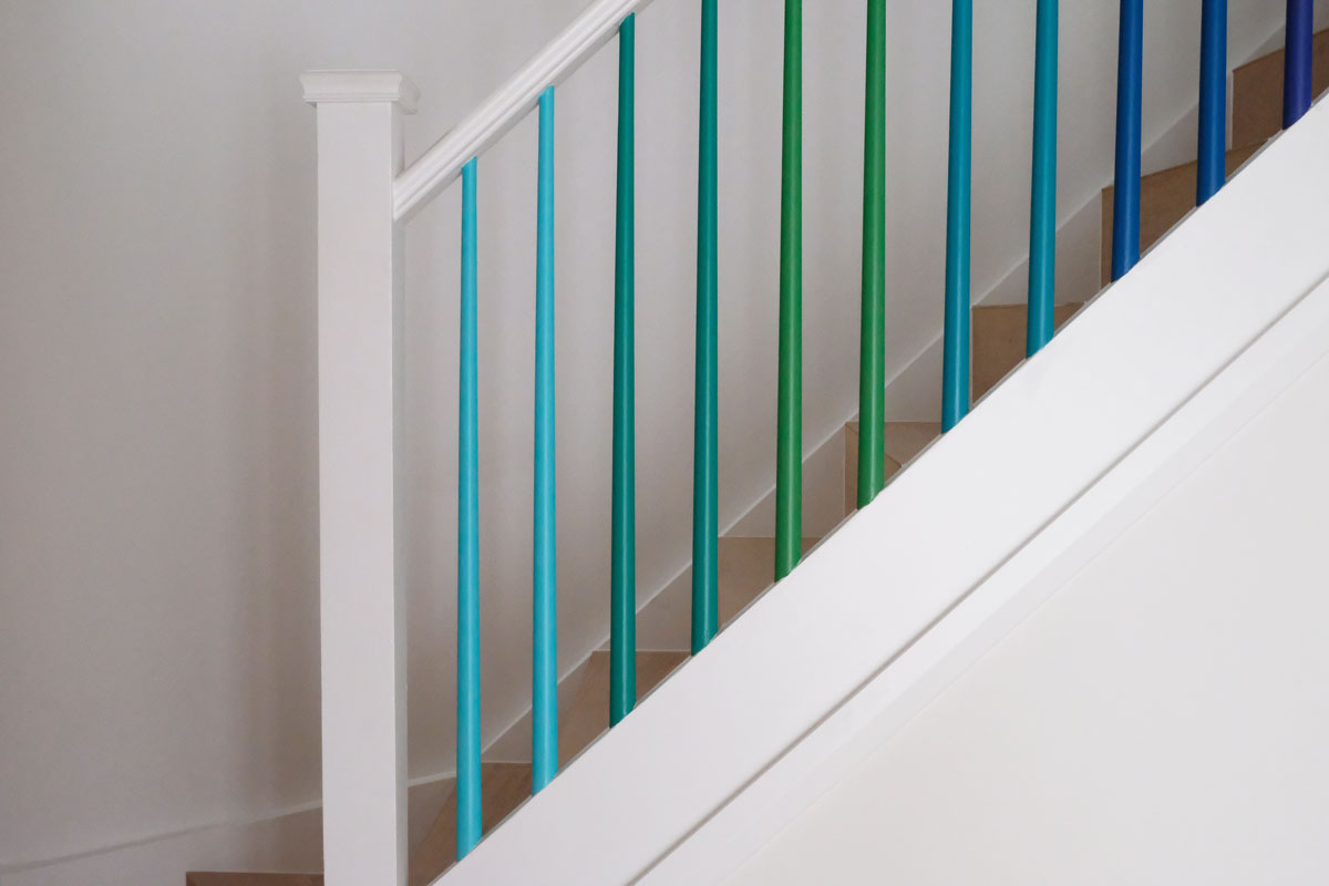 Multi-colored stair banisters and white railing