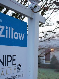 Owned by Zillow sign is seen outside a single-family home for sale in West Linn, Oregon, What Does Zillow Estimated Payment Include? [HOA, Taxes And More]