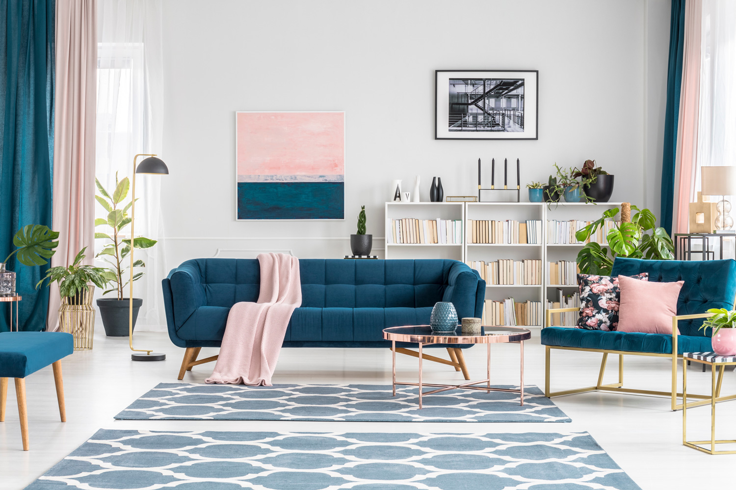 Patterned carpet in luxurious living room interior with blue sofa against white wall with pink painting
