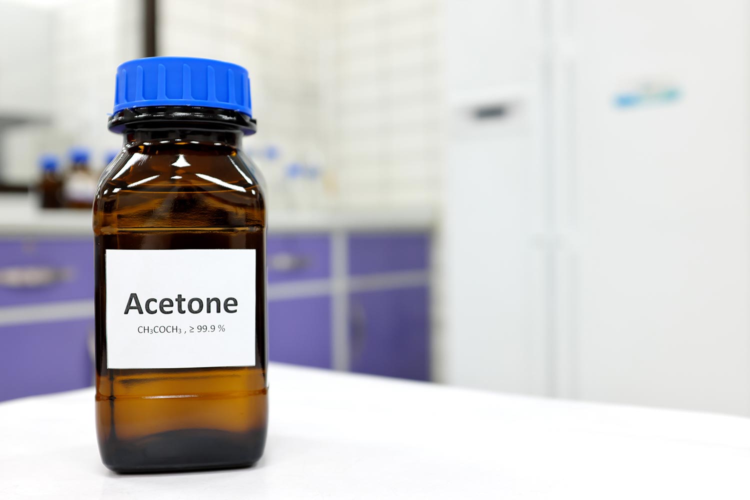 Selective focus of pure acetone solution in brown glass amber bottle inside a chemistry laboratory