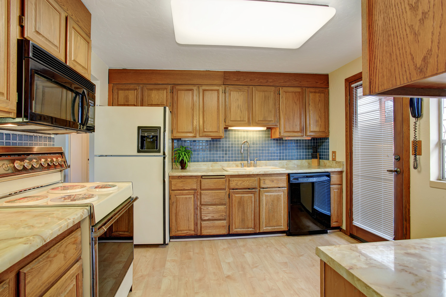 Simple kitchen with hardwood floor and a door.
