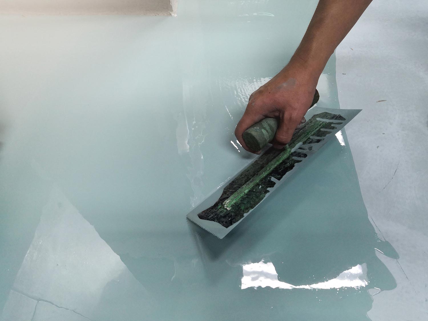 Spreading self leveling compound with trowel.Self-leveling epoxy