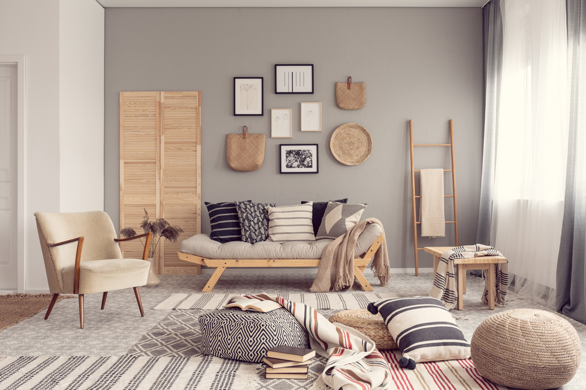 Stylish living room interior design with scandinavian settee, grey wall and natural accents