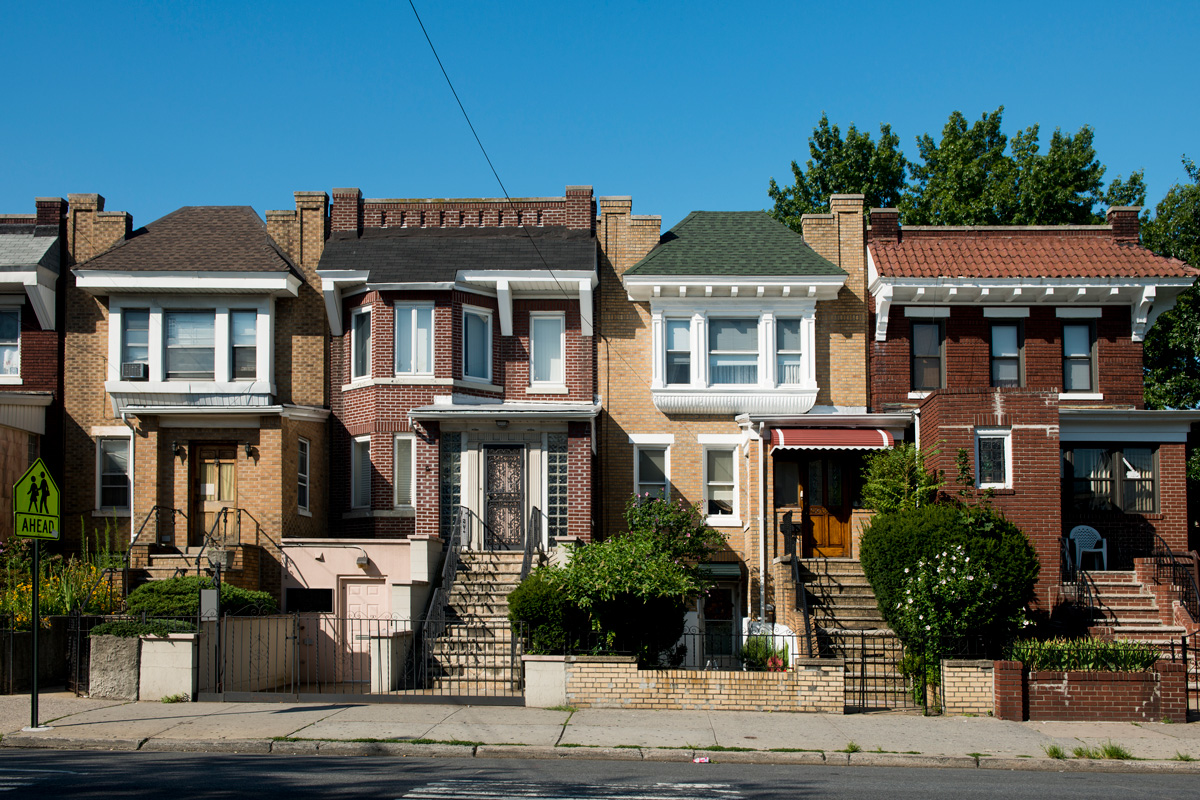 This is a horizontal, color photograph of brick homes in the Astoria neighborhood of Queens, New York.