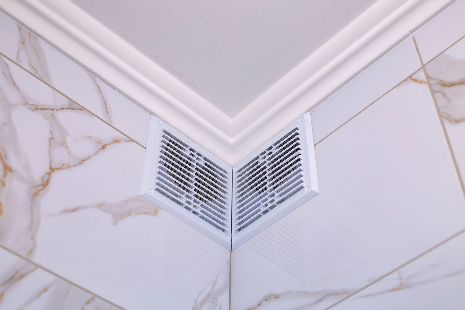 Two wall vents at a wall with marble cladding