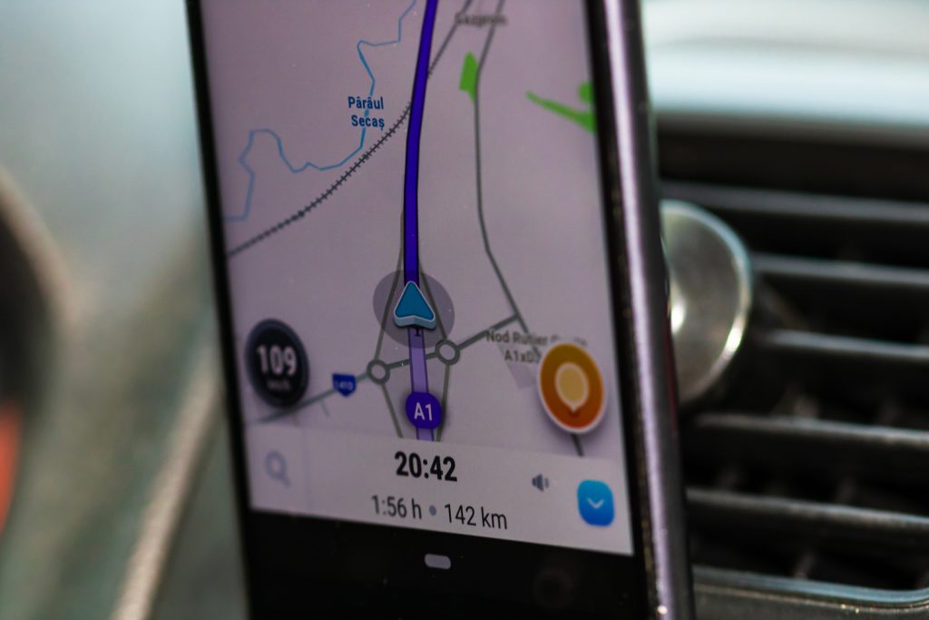 Using waze maps application on smartphone on car dashboard, close up of application.