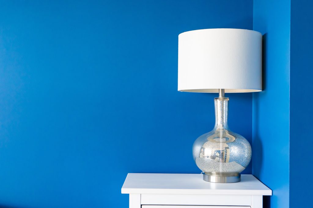 Vibrant blue painted wall with white home decor accents 