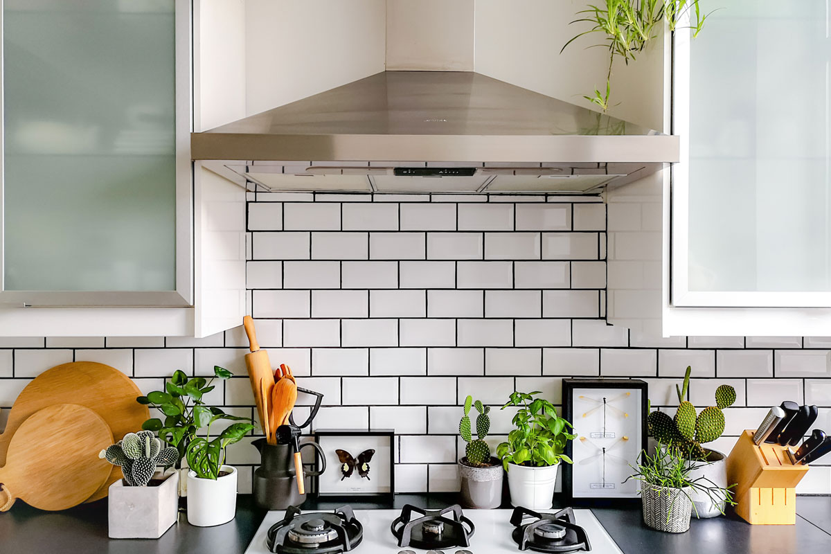 White brick subway tile used for a backsplash in the kitchen with small basil leaves