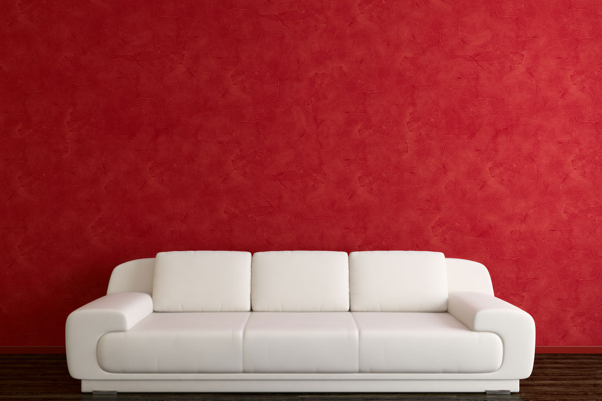 White sofa in front of red wall Dark wooden floor