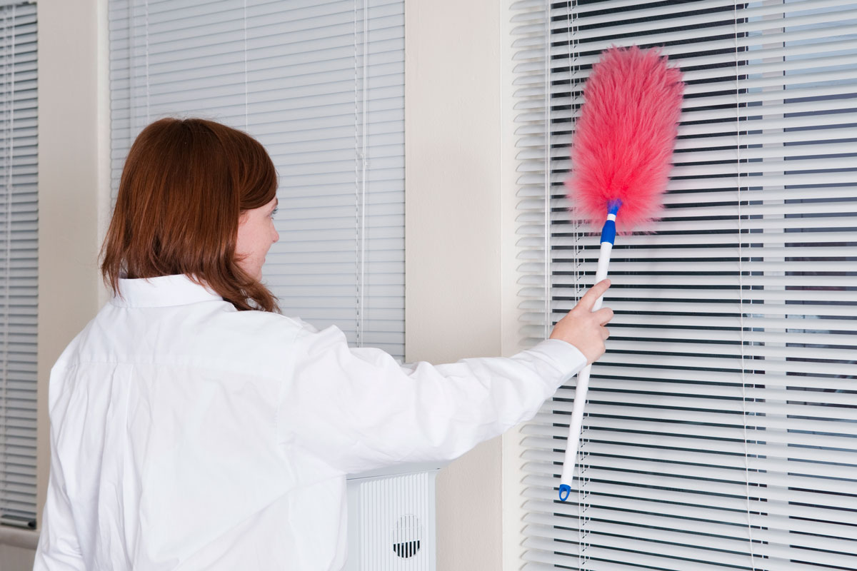 Woman cleaning the blinds