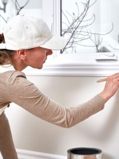 Woman painting on trim wall, Can You Use Trim Paint On Walls? [And Vice Versa]