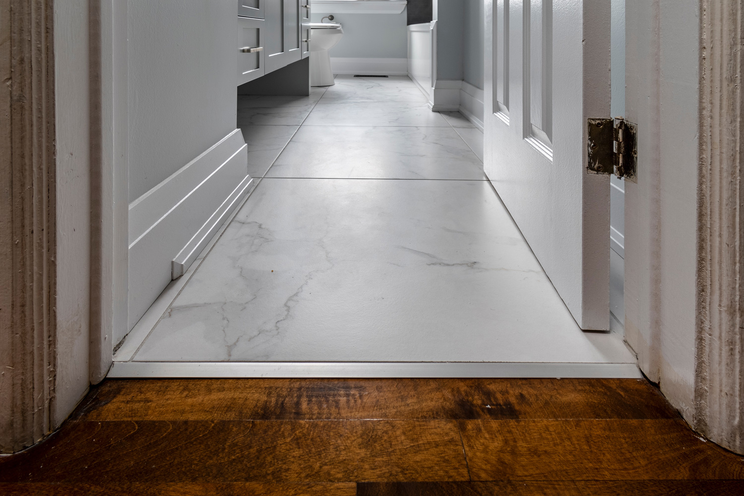 Wood floor transition to ceramic flooring - Bathroom renovations modern.
