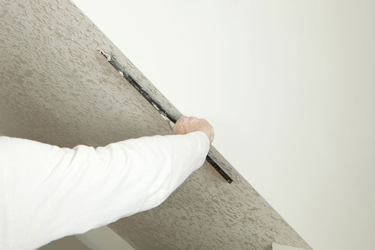 Worker Troweling Drywall Mud on a Ceiling for Knockdown Texture