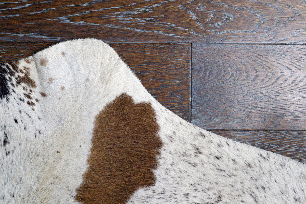 Zebu silver cowhide leather and hair details with brown engineered hardwood floor