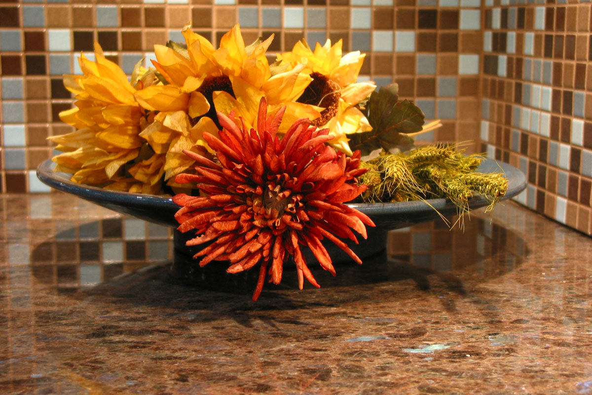 brown granite in kitchen with warm orange, white, gray box bricks design with flower decoration