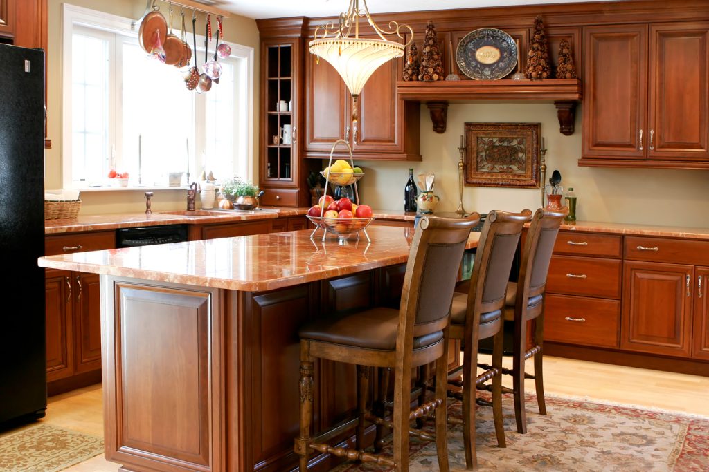 modern luxury kitchen with cherry cabinets and granite countertops, showing a center island with chairs