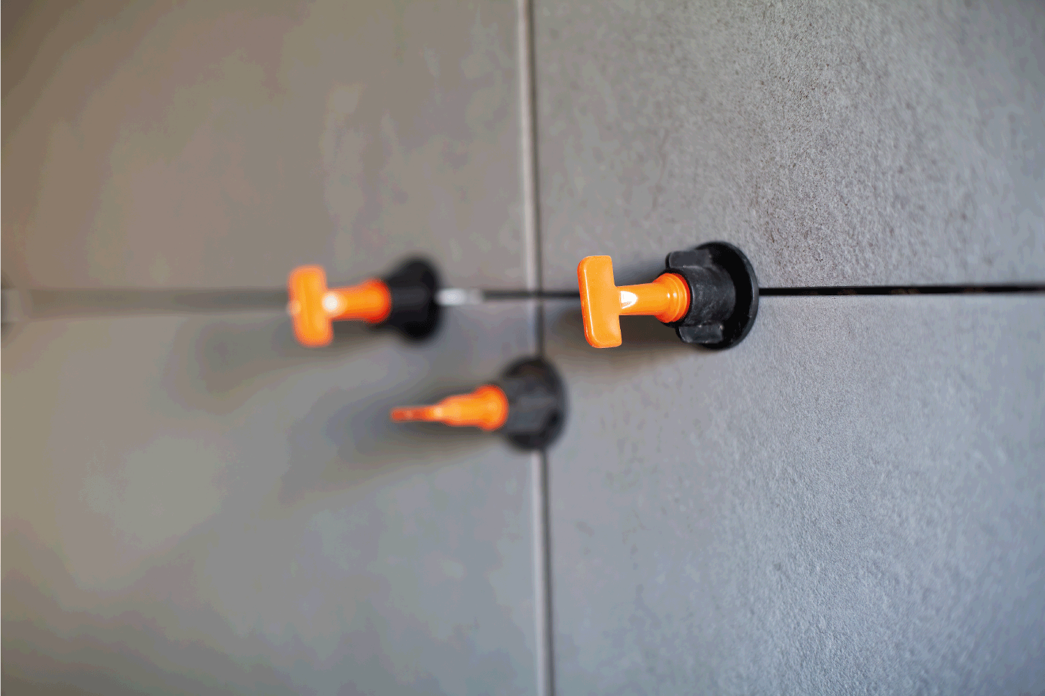 orange leveling spacers used on newly installed wall tile pieces