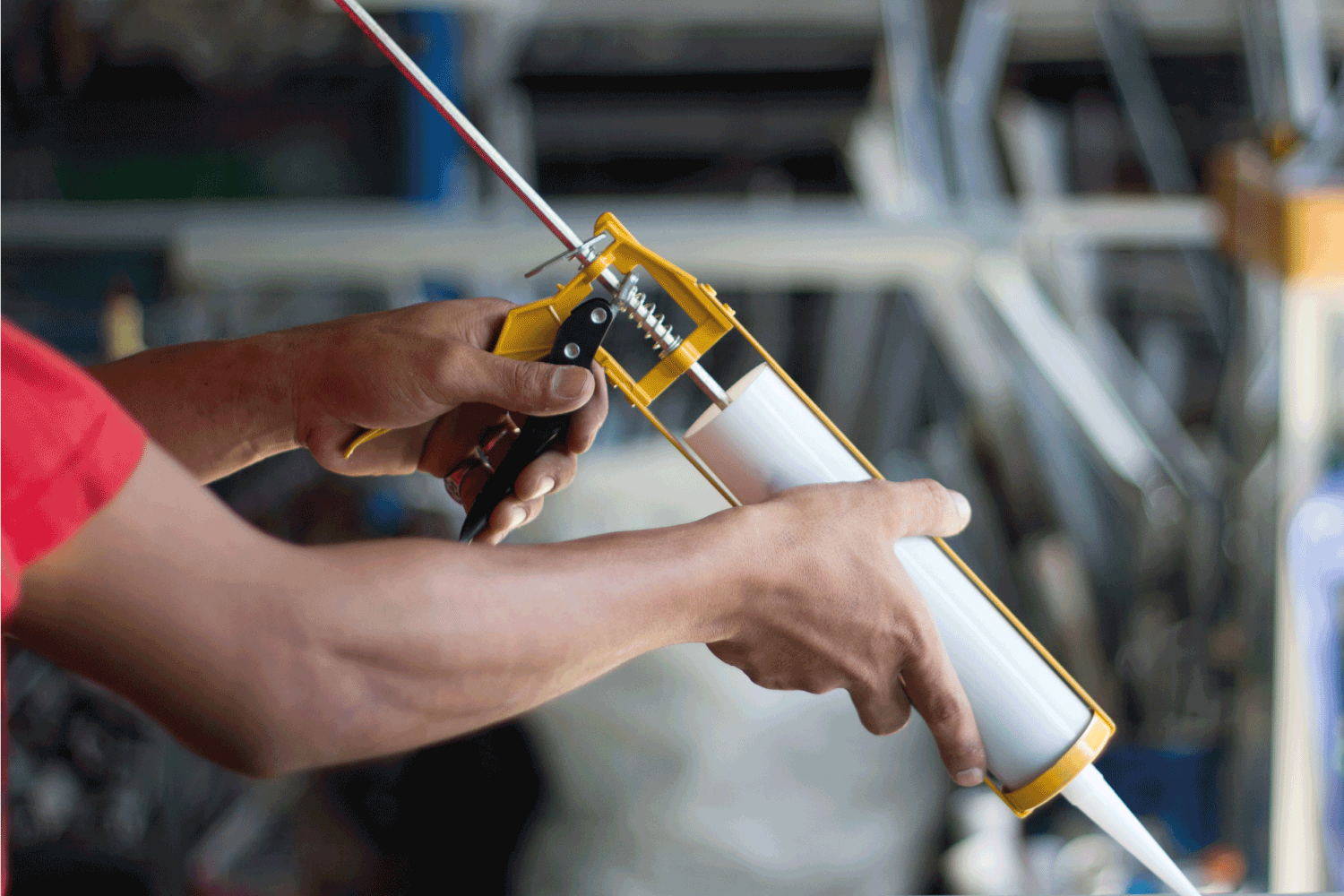 worker using caulk gun applying sealant