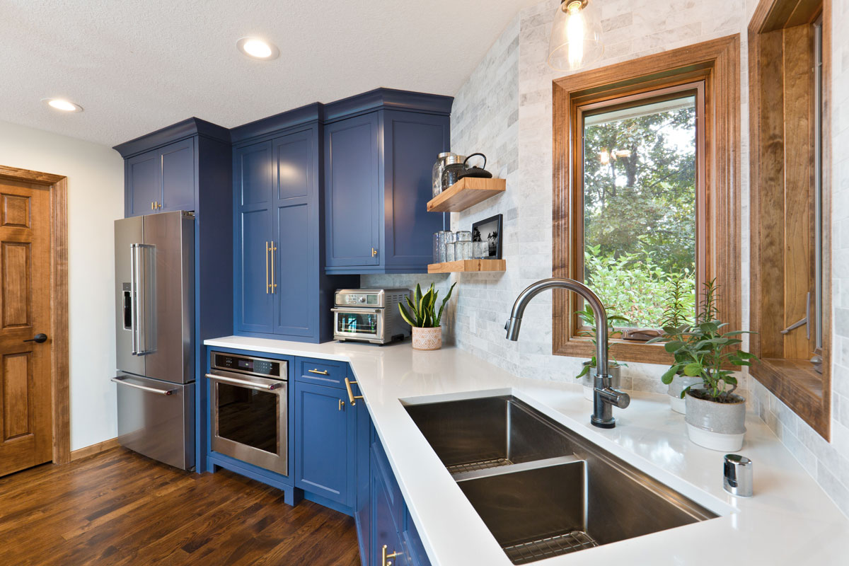 A contemporary kitchen renovation remodeling featuring a hardwood floor kitchen sink, appliances and quartz counter top