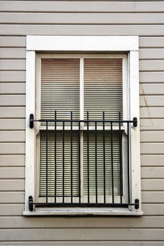A double hung window with white painted window trims and guard rails