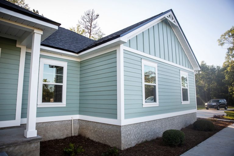 A house wooden siding painted in a turquoise color with white painted trims and black asphalt shingle roofing, How To Stop Mice From Getting Under Siding