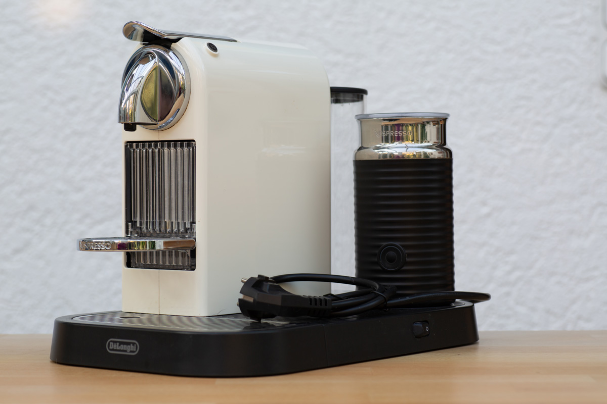 A white Delonghi coffee machine next to a Nespresso frother